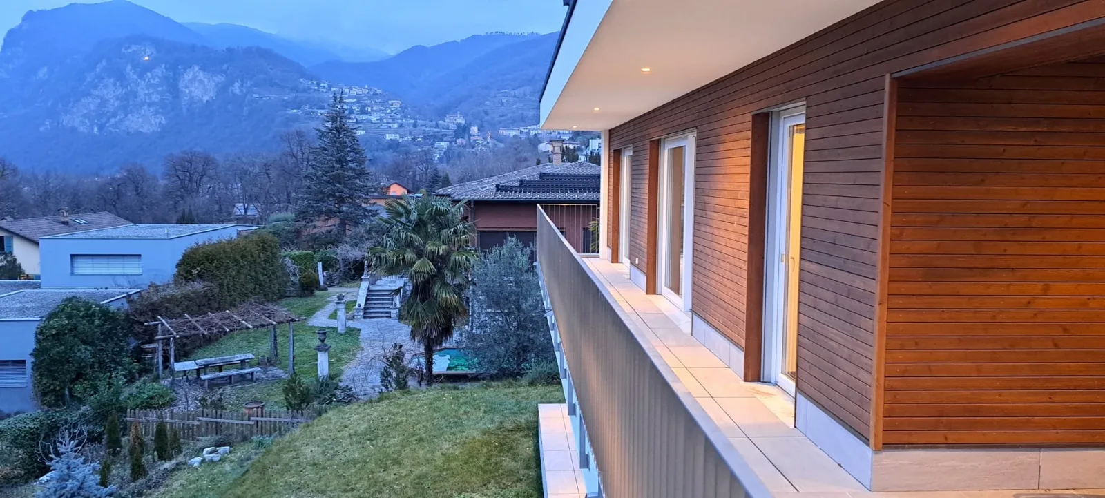 Balcone in legno con luci accese al crepuscolo